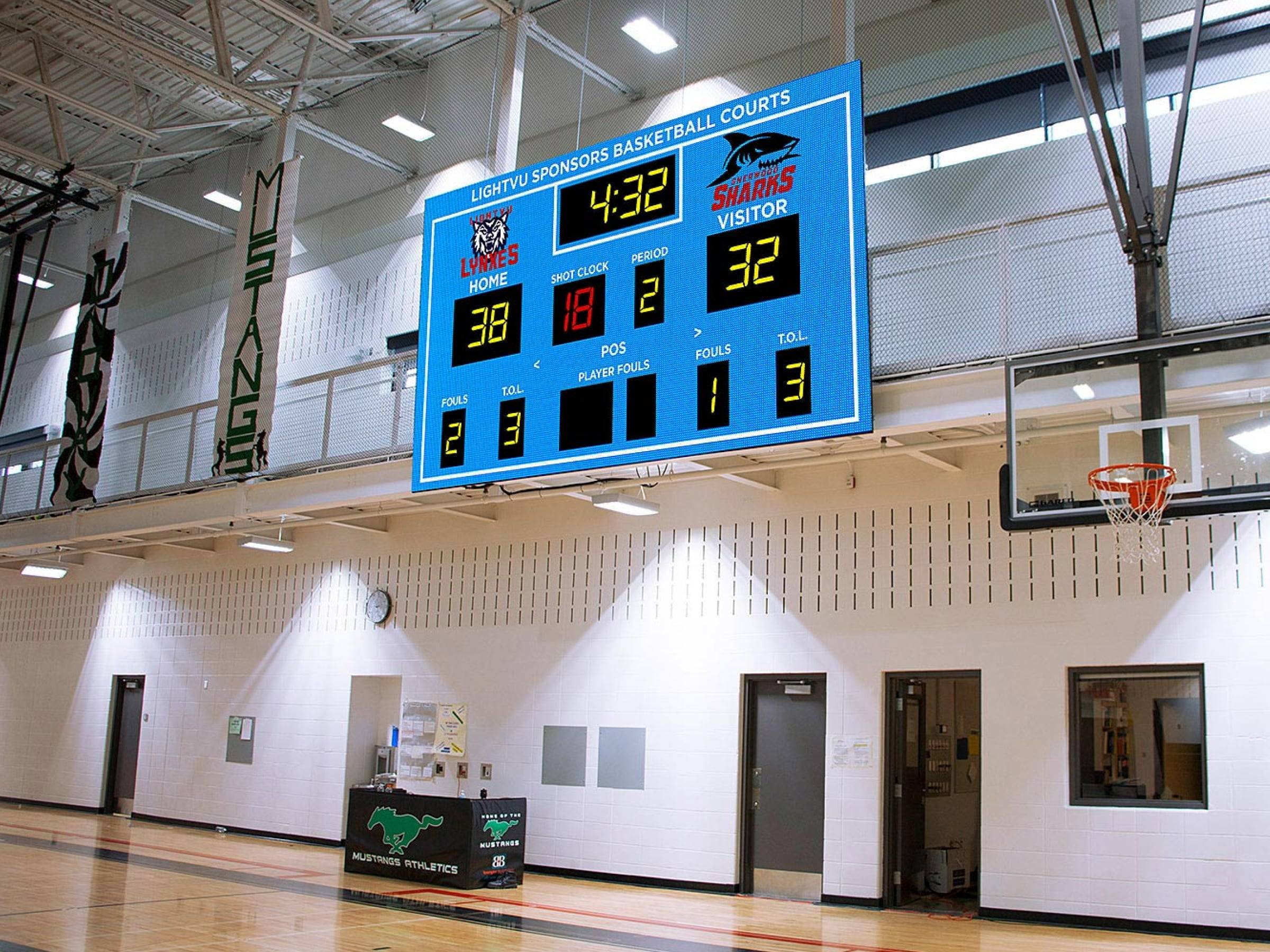 scores of the game displayed on a digital display screen on a basketball court.