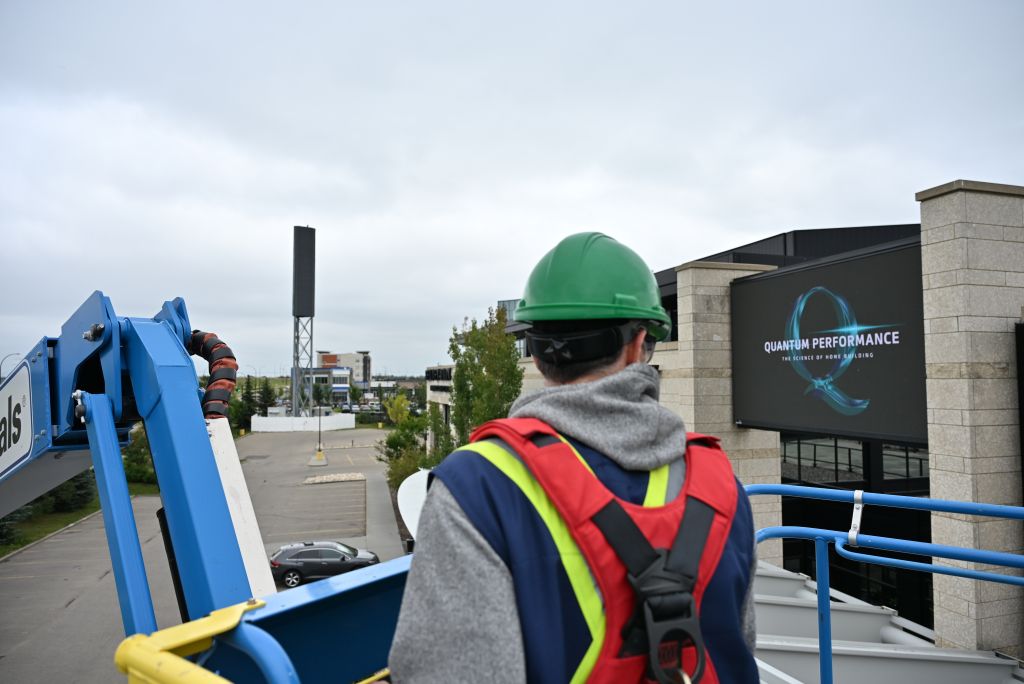 Digital Signage Service & Maintenance Technician inspecting and maintaining a digital signage display.